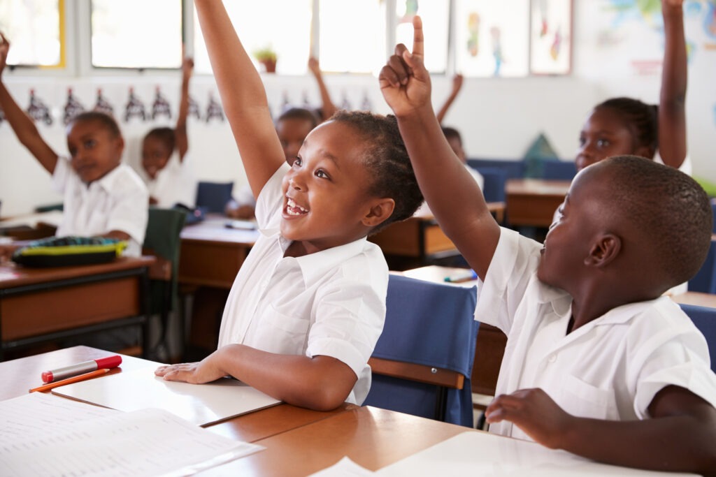 Kids raising hands during elementary school lesson